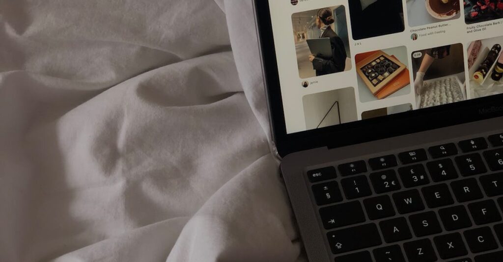 A close-up of a laptop on a bed showing a social media platform.